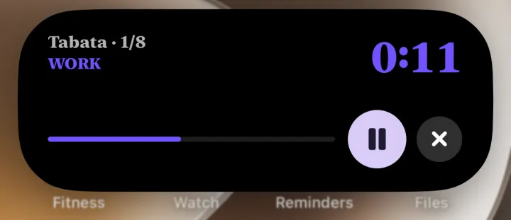 The Dynamic Island opened: Tabata, round 1 of 8, work, 11 seconds, a progress bar and pause and end buttons, in a purple serif agent look